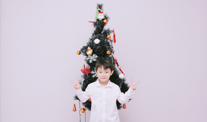 An asian boy wears a casual dress for christmas. Season's greetings.
