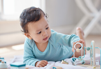 Baby, playing and toys on floor in home with learning, development and morning in nursery. Child,...
