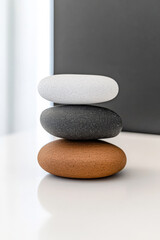 Stacked stones in neutral colors on a white surface creating a minimalist aesthetic indoors