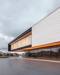 Obraz premium Modern architectural design of a sleek building with large windows during an overcast day
