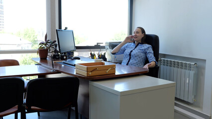 Caucasian woman sits in office talking on phone and negotiating business deal modern woman....