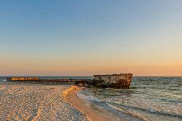 The hull of the ship after the accident, which is lying on the shore. An old shipwreck lies on a...