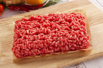 Raw minced beef meat over board