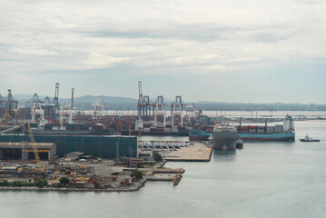 container ship commercial vessel alongside in port for loading and discharging containers services in maritime transports in World wide logistics