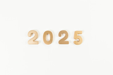 2025 Happy New Year. Top view of gold numbers on white background. Copy space, flat lay.