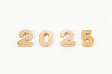 2025 Happy New Year. Top view of gold numbers on white background. Copy space, flat lay.