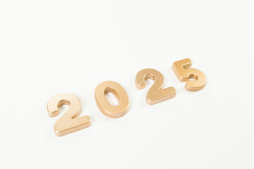 2025 Happy New Year. Top view of gold numbers on white background. Copy space, flat lay.