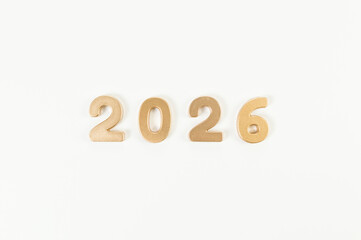 2026 Happy New Year. Top view of gold numbers on white background. Copy space, flat lay.