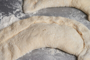 Close-up of an elderly woman's hands preparing cheese-filled panzerotto in a rustic pan, highlighting traditional cooking techniques.