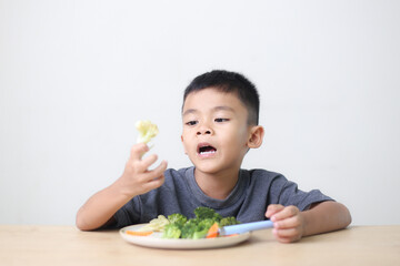 Nutrition healthy eating habits for kids concept. Children do not like to eat vegetables. Little cute boy refuses to eat healthy vegetables.