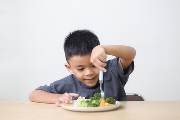 Nutrition healthy eating habits for kids concept. Children do not like to eat vegetables. Little cute boy refuses to eat healthy vegetables.