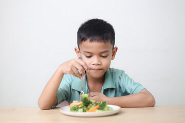 Nutrition healthy eating habits for kids concept. Children do not like to eat vegetables. Little cute boy refuses to eat healthy vegetables.
