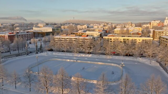 Aerial tracking shot of a ice hockey rink in Kuopio, winter sunset in Finland