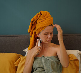 Young woman using infrared massager 