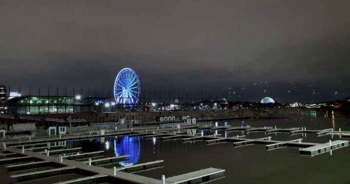 Static night panoramic shot of &Icirc;le Sainte-H&eacute;l&egrave;ne with a view of Old Port, Parc Jean-Drapeau, La Ronde, Le Monstre and a flock of birds in the city of Montreal, Canada