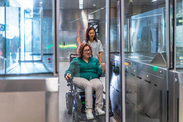 Disabled woman in wheelchair and friend entering at metro station