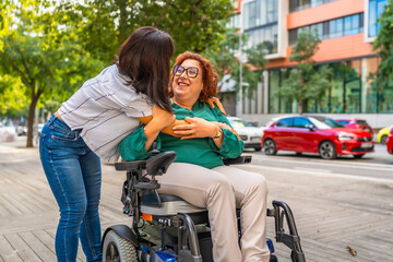 Woman in wheelchair and friend hugging in the street