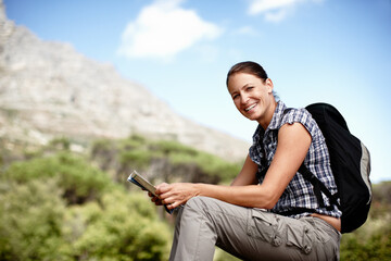 Naklejka premium Hiking, woman and map in nature with portrait, direction and journey navigation at space. Happy person, backpack or geography diagram on mountain for trekking, travel planning or guidance in Portugal