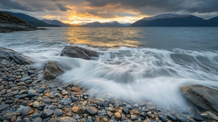 Obraz premium A serene coastal scene at sunset with waves gently lapping against rocky shores.