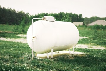 Large white propane gas tank providing clean energy to a rural home