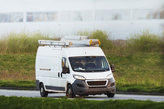 Van with ladder and tools driving on road