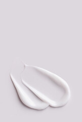 cosmetic smears of creamy texture on gray background