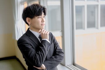 心配そうに外を見るビジネスマン