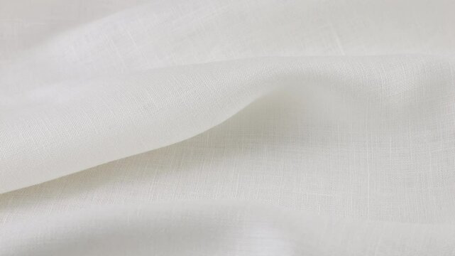 Soft folds of the white linen fabric rotates on the showcase. Top view of textile background. Theme design, fashion, tailoring of clothes.