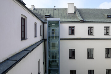 Modern outdoor elevator in old historic hotel building