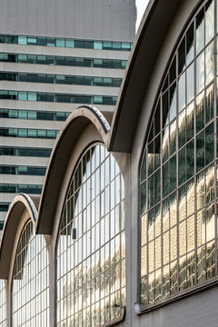 Rows of arched, reflective windows echo a modern cityscape, juxtaposing classic architectural curves with sleek, contemporary building designs and reflections 