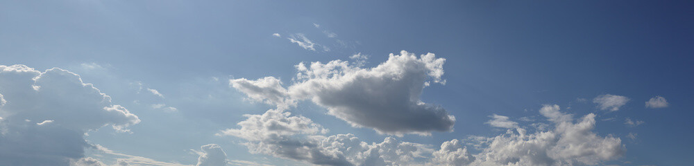 Panoramic photo of blurred sky. Blue sky background with cumulus clouds