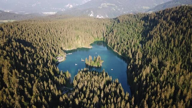 Aerial shot of the stunning Cauma Lake, Caumasee, a picturesque alpine lake nestled amidst a dense forest and majestic mountains in Graub&uuml;nden, Switzerland