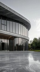 Fototapeta premium Modern architectural design, curved glass building against green landscape.