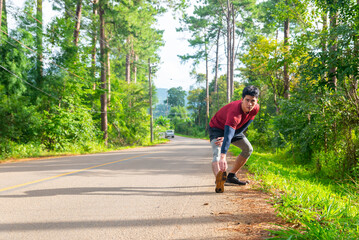 Asian man athlete in sportswear warm up exercise before running on nature trail on mountain. Healthy people enjoy outdoor active lifestyle travel natural park with sport training workout in summer.