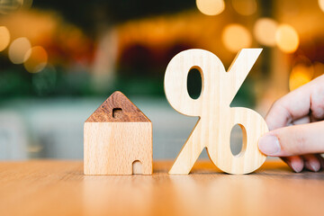 Percentage and house sign symbol icon wooden on wood table. Concepts of home interest, real estate, investing in inflation.