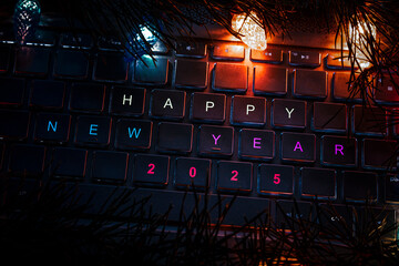 laptop keyboard surrounded by lights of a Christmas garland. Christmas decorations on computer....
