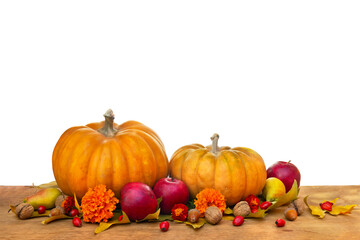 Pumpkin, yellow pears, apples and autumnal colorful maple leaves on wooden table on a white background with space for text