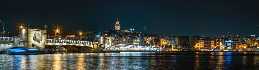 Obraz premium The historical symbol of Istanbul, Galata Tower. View of Istanbul in the dark at night. The unique view of the sea and Galata Tower combined.Istanbul, Turkey.