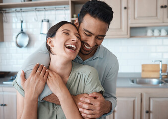 Couple, laughing and embrace in kitchen together for intimate moment, funny joke and connection in...