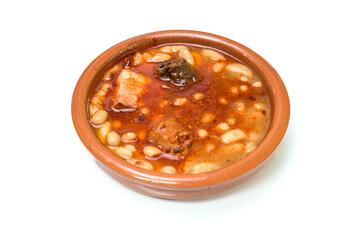 Clay casserole with Asturian fabada, surrounded by traditional ingredients such as garlic, bread and sausages. Typical dish of Spanish cuisine, ideal for gastronomy and traditional recipes