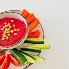 Beet Hummus Dip with Chickpeas on Top and Vegetables on Plate