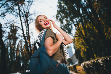 Photo of attractive young cheerful lady laugh turn around backpack wear khaki garment tied...