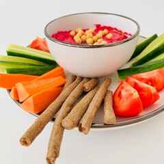 Beet Hummus Dip with Chickpeas on Top and Vegetables on Plate