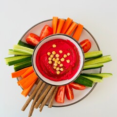 Beet Hummus Dip with Chickpeas on Top and Vegetables on Plate