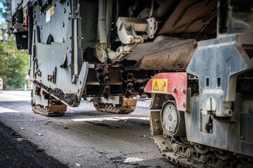 Asphalt Milling Machine Removing Old Asphalt Layer on Road. Closeup. Asphalt milling.
