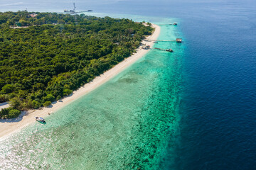 Aerial view of a tranquil lagoon with wooden docks and small boats off the coast in a tropical paradise