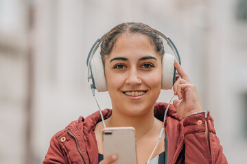 young woman with dental braces with mobile phone and headphones