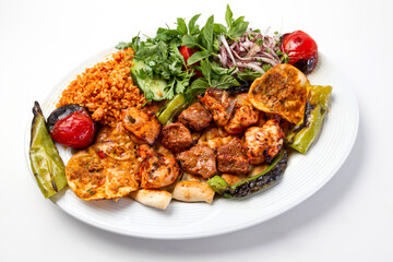 Turkish kebab lamb meat on skewer.
with vegetables and rice on a serving plate