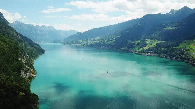 a sailboat gliding on Lake Walen (Walensee) turquoise waters in eastern Switzerland ,the world-famous Heidiland for heidilandHeidi story, Walensee, Switzerland