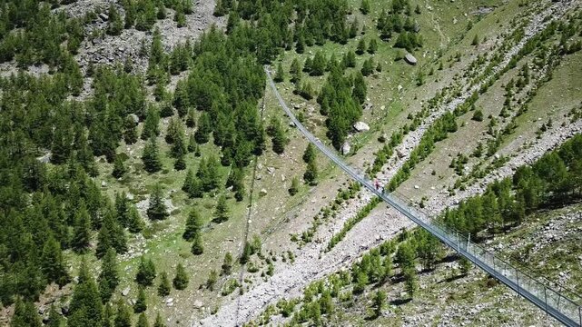 Breathtaking aerial footage of adventurous tourists crossing the modern bridge, nestled amidst the stunning alpine scenery, Charles Kuonen H&auml;ngebr&uuml;cke Bridge, Randa, Wallis, Switzerland
